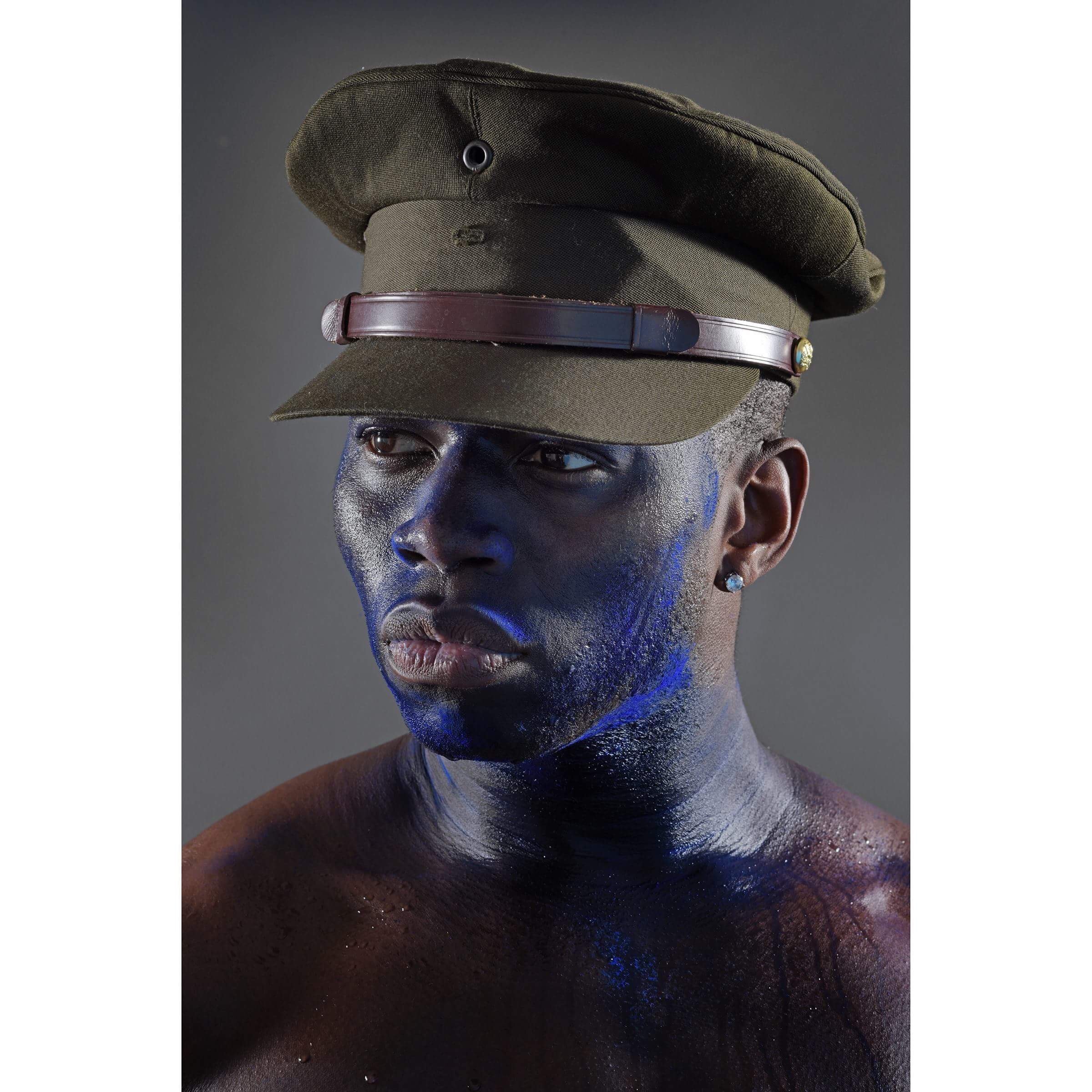 Man wearing military cap with blue face paint