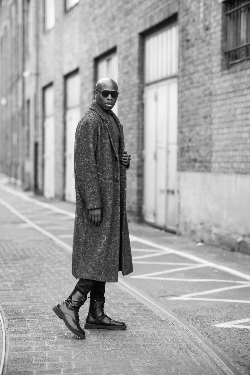Man in leather jacket emerging from doorway