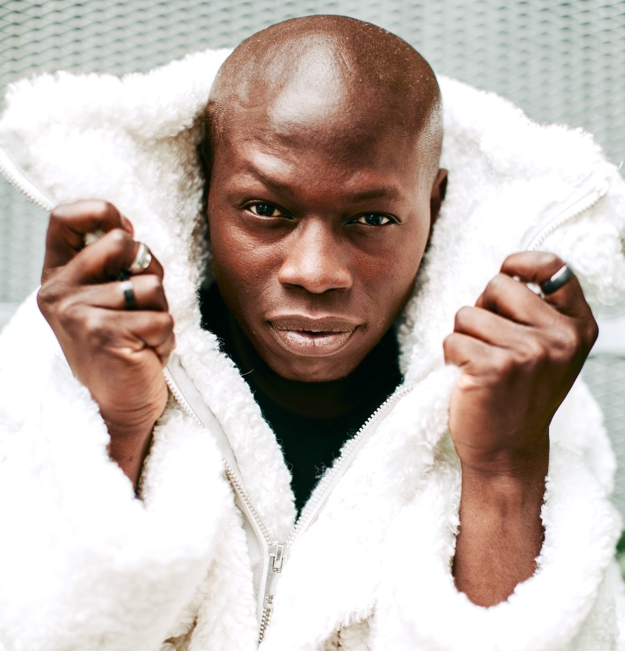 Man in white fluffy jacket fists raised close-up