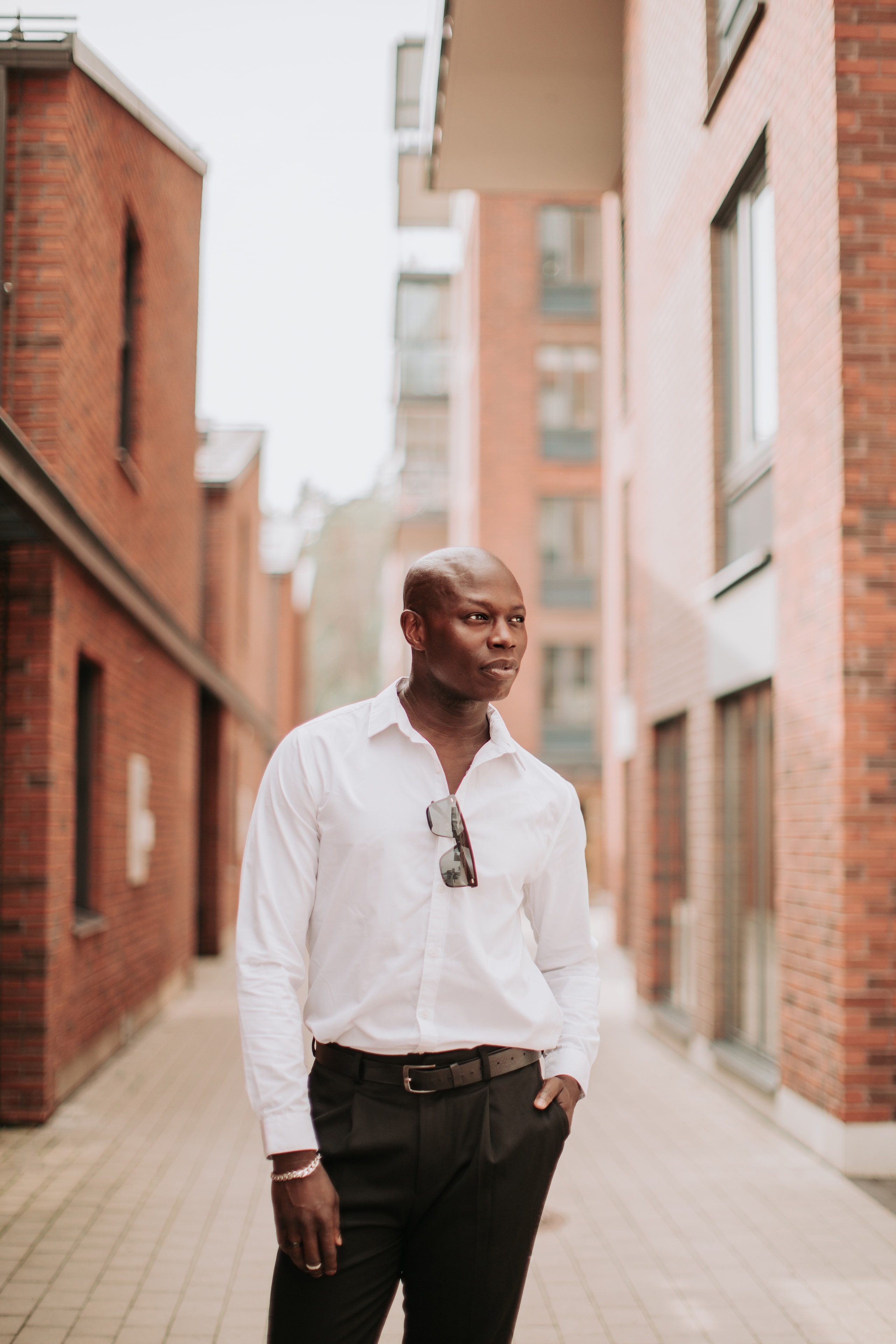 Man in white shirt standing in brick alley